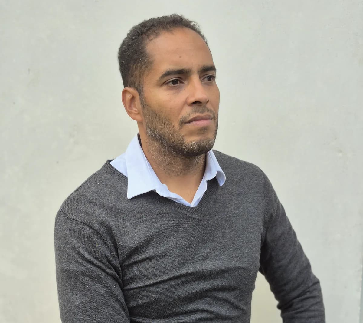 Yurniel Lahera adossé à un mur clair, une main sur la hanche, le regard hors champ